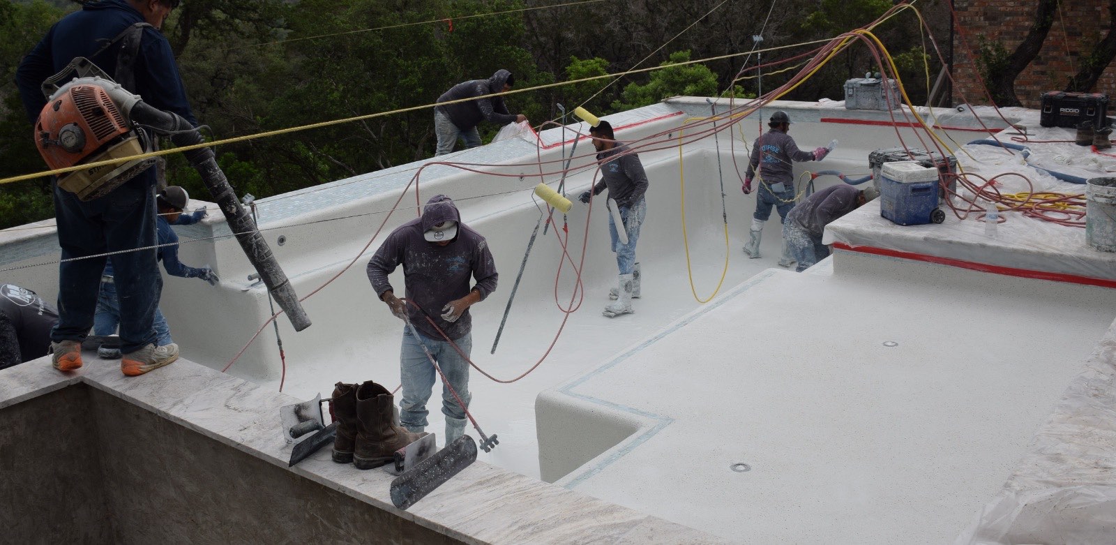 Crew applying a fresh pool finish over the gunite shell on a J. Oliver Pools build in the Texas Hill Country