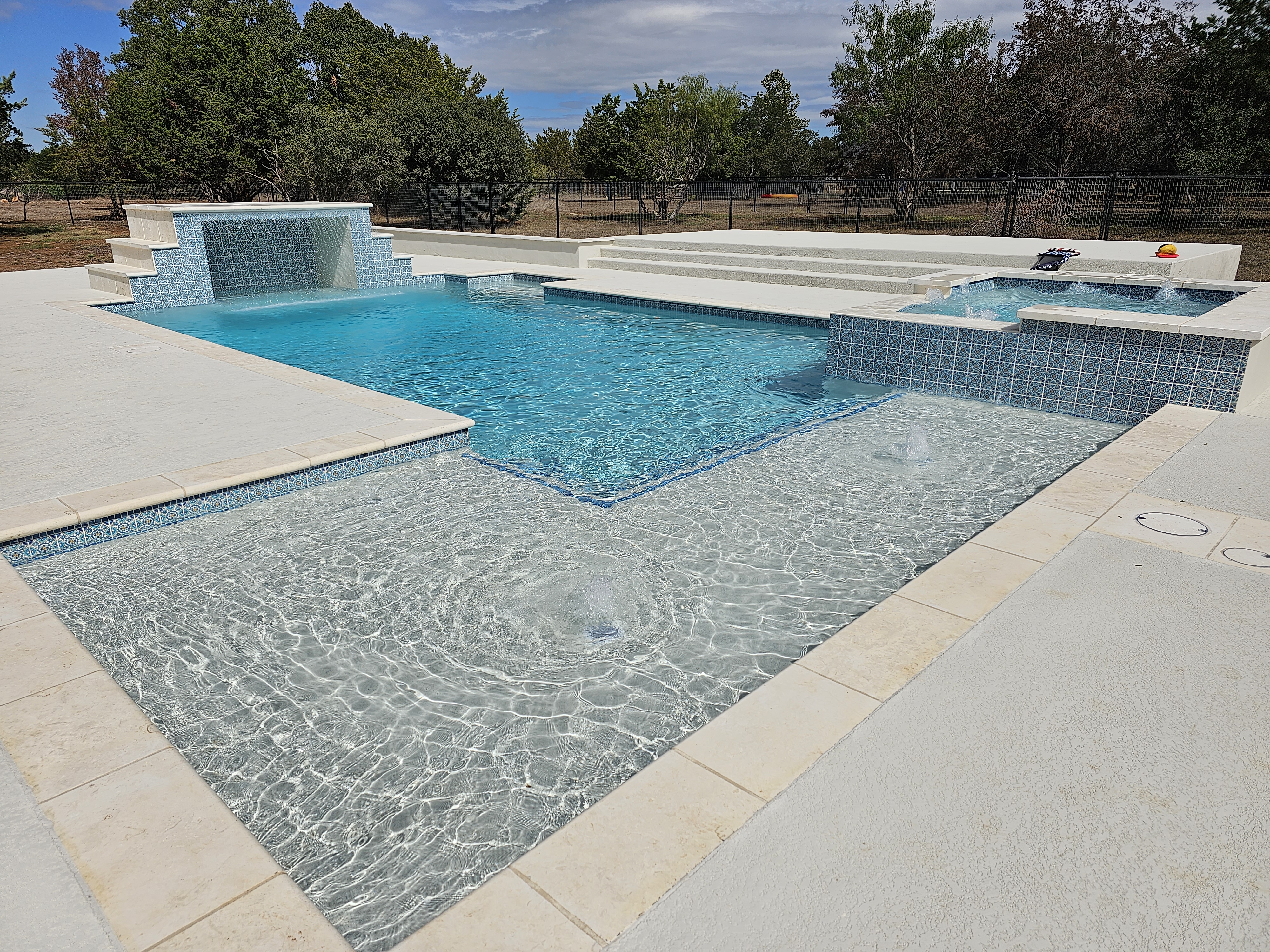 Crystal-blue custom gunite pool with raised spa built by J. Oliver Pools in Belle Oaks