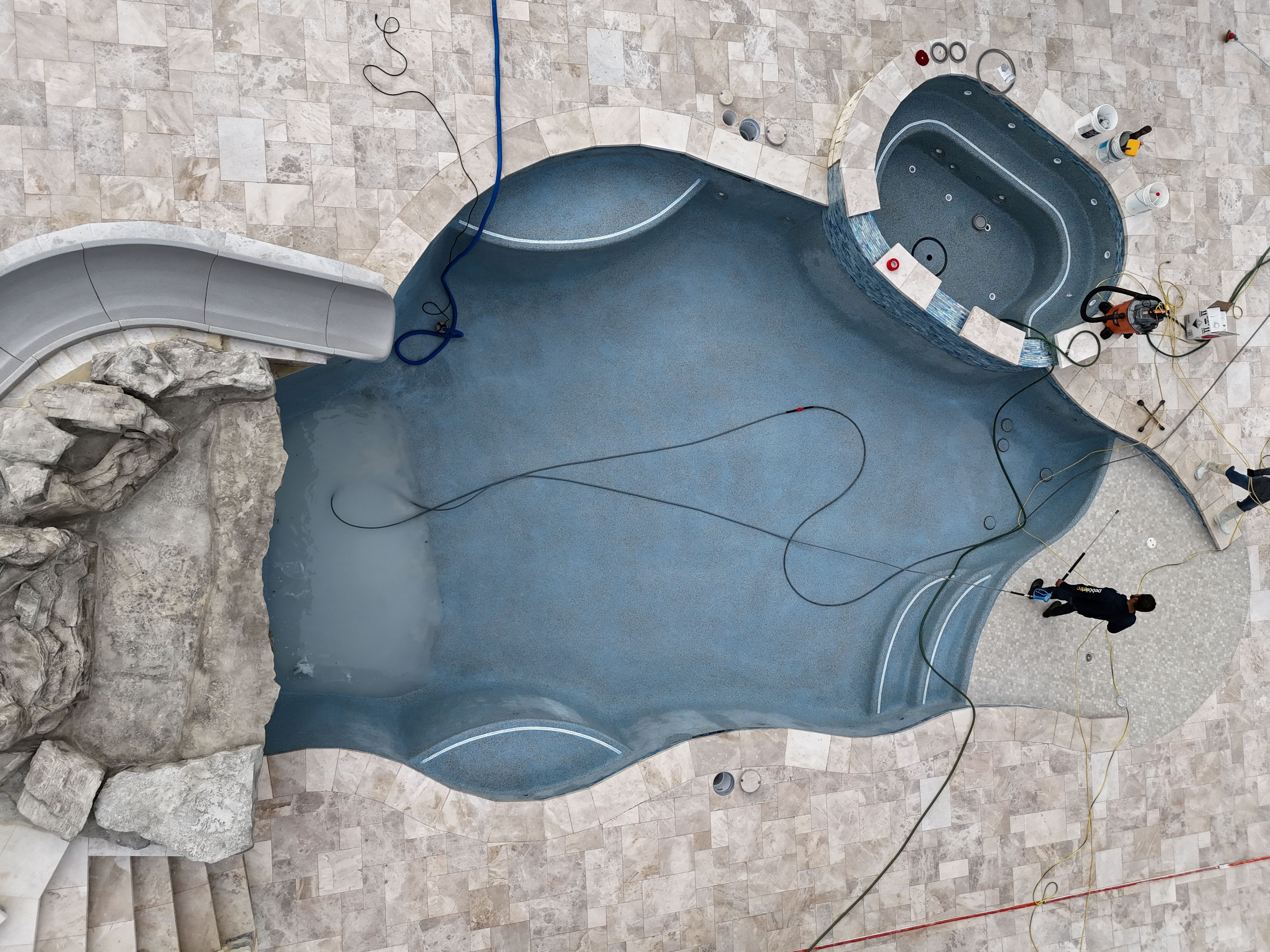 Aerial view of a freeform gunite pool with rock grotto and slide in Thornebrook, Bulverde TX