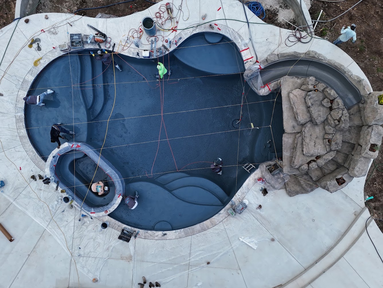 Fresh PebbleTec finish being applied to a gunite pool interior in New Braunfels, Texas