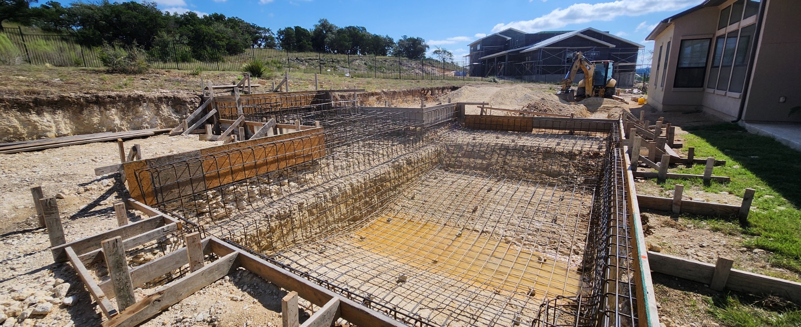 Pool construction site with steel rebar and gunite forms before build, New Braunfels Texas