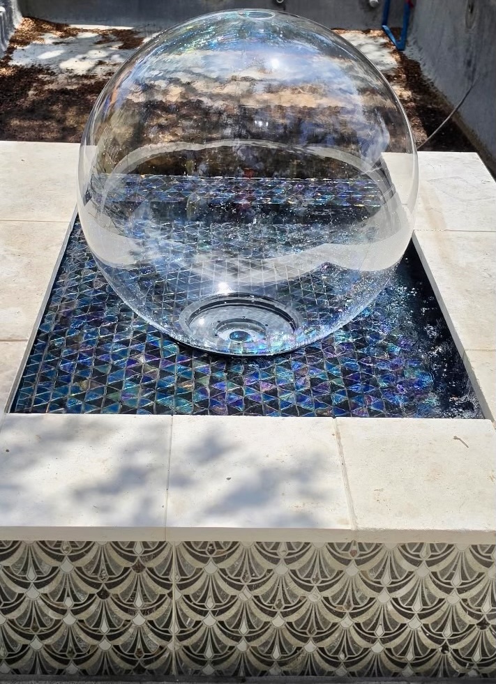PAL Pool Water Sphere glass orb glowing with light over glass-tile pool feature