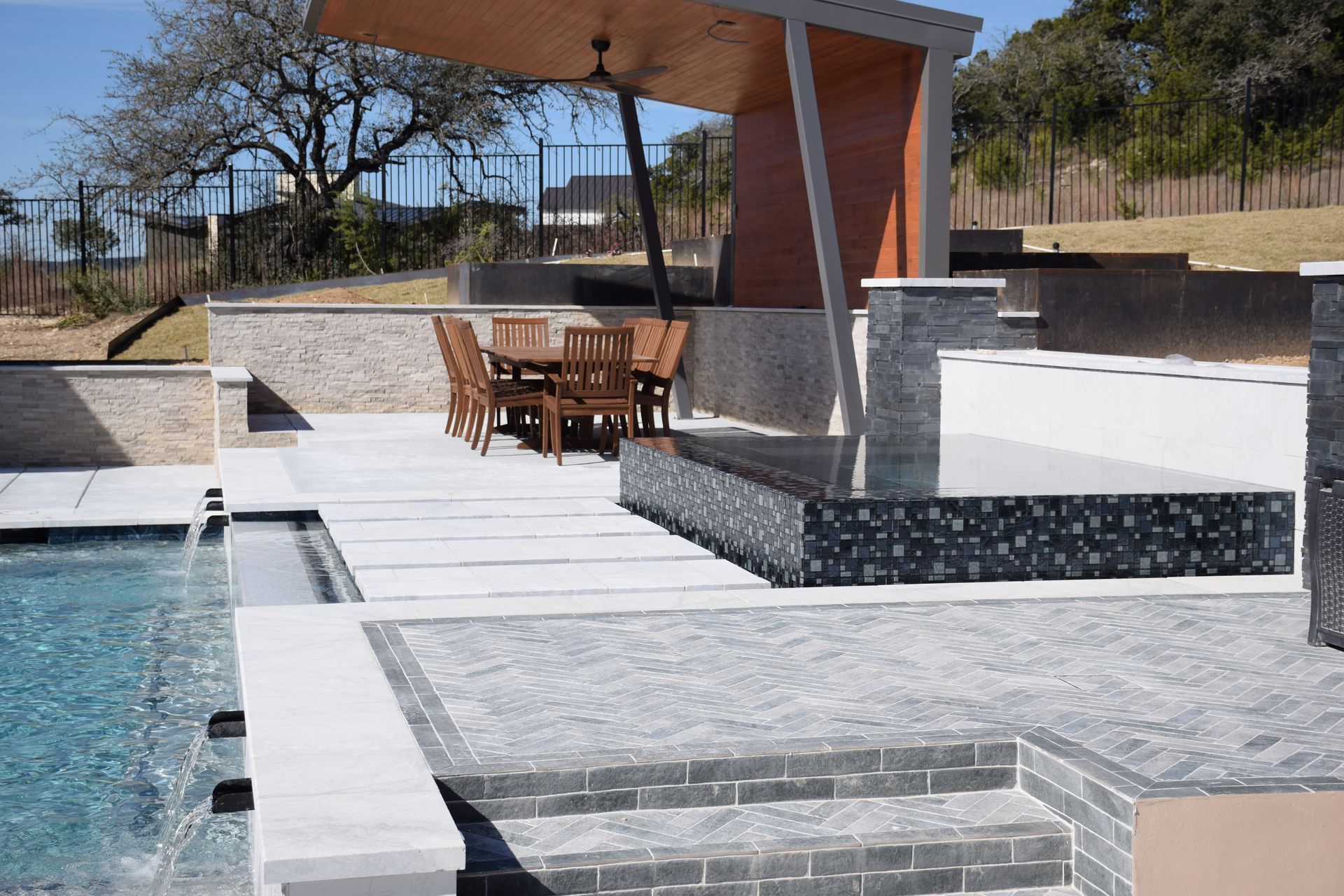 Modern pavilion with raised black-tile spa built by J. Oliver Pools in Havenwood